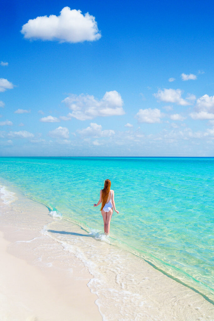 a girl with her back towards the camera standing in the water