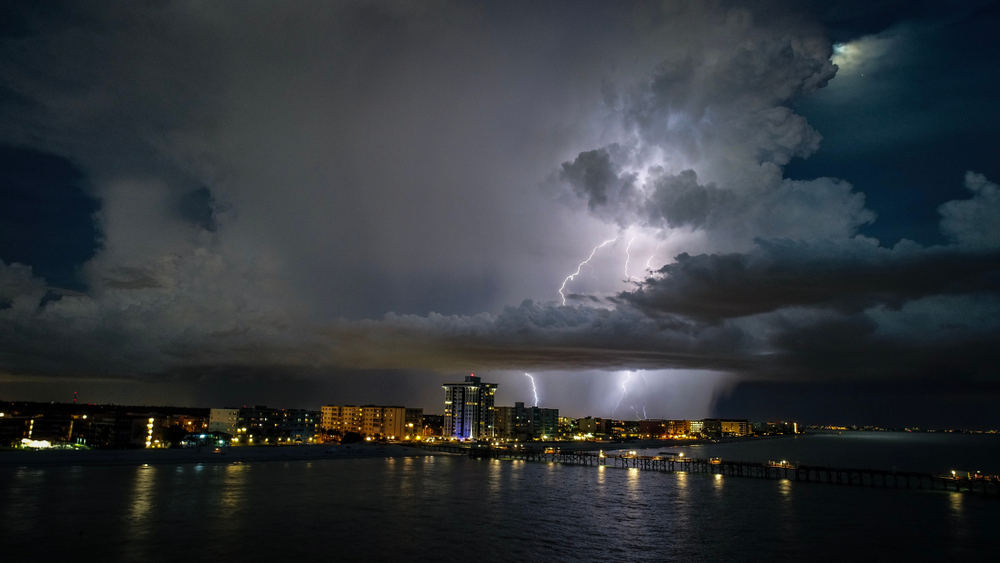 A huge blot lightning brightens the night sky and clouds above the Tampa skyline. 