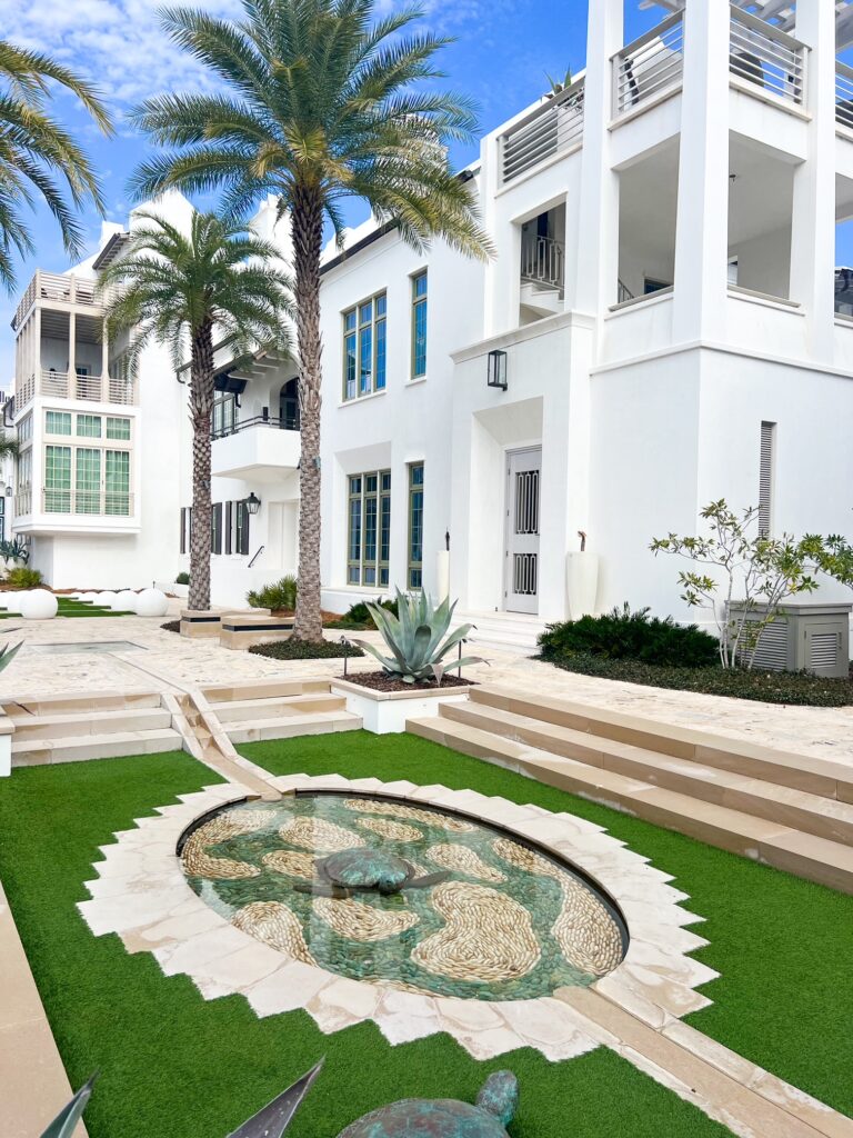 the courtyards surrounded by white buildings and palm trees and manicured courtyards in ALYS