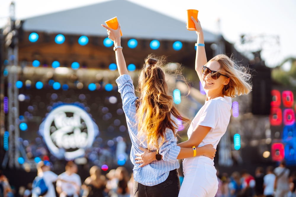 two girls with hands in air enjoying a music festival there are plenty of music festivals when look at things to do in 30A