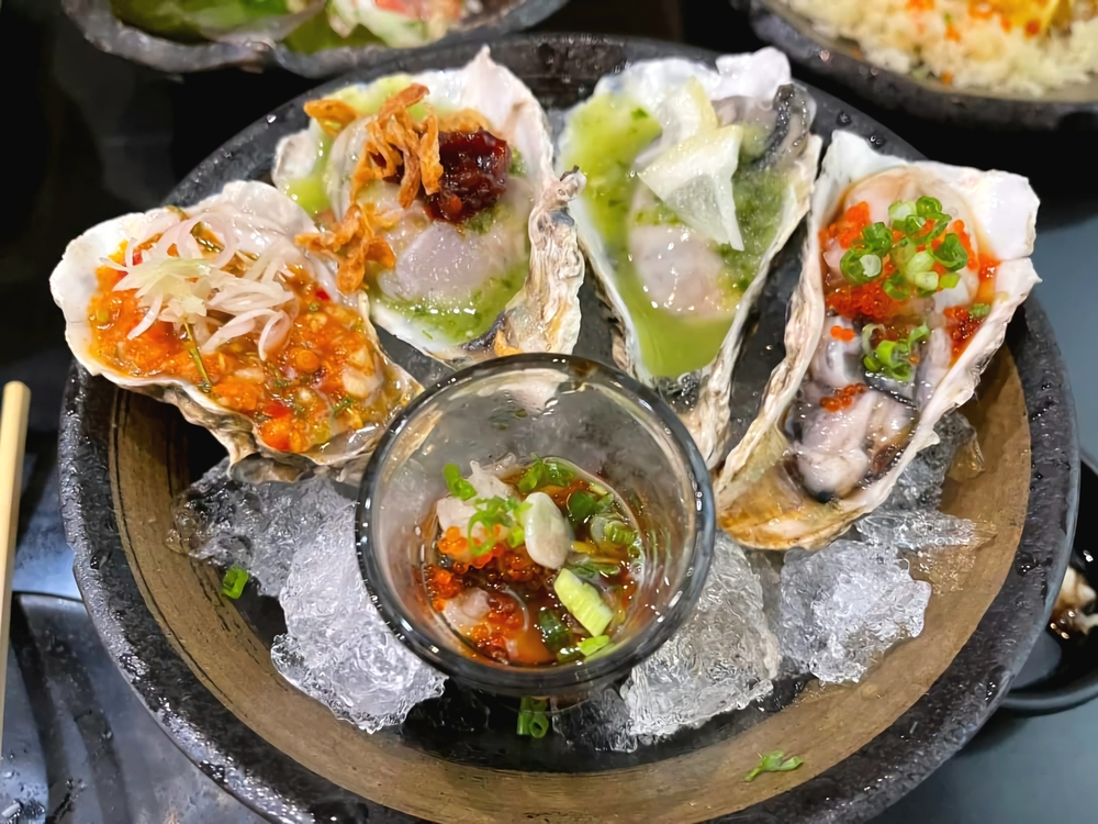 a plate with 4 different style oysters at one of the best restaurants in 30A with a variety of toppings