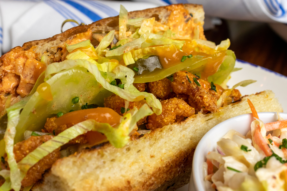 a shrimp po boy sandwich with a side of Cole slaw