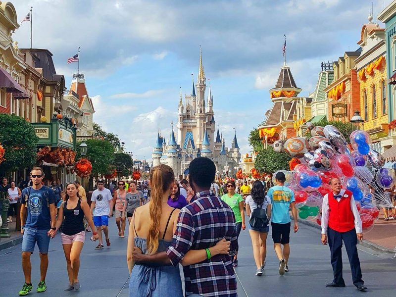 a couple hugging in front of Cinderellas castle on Main Street in Walt Disney World