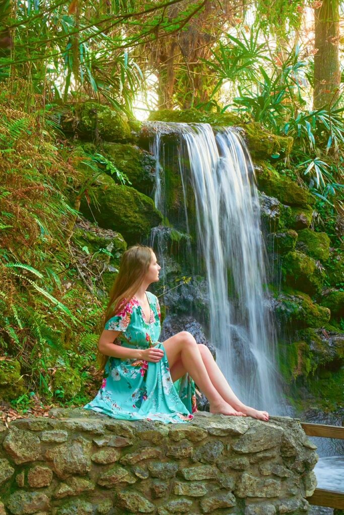 Girl sat in front of waterfall at Rainbow Springs