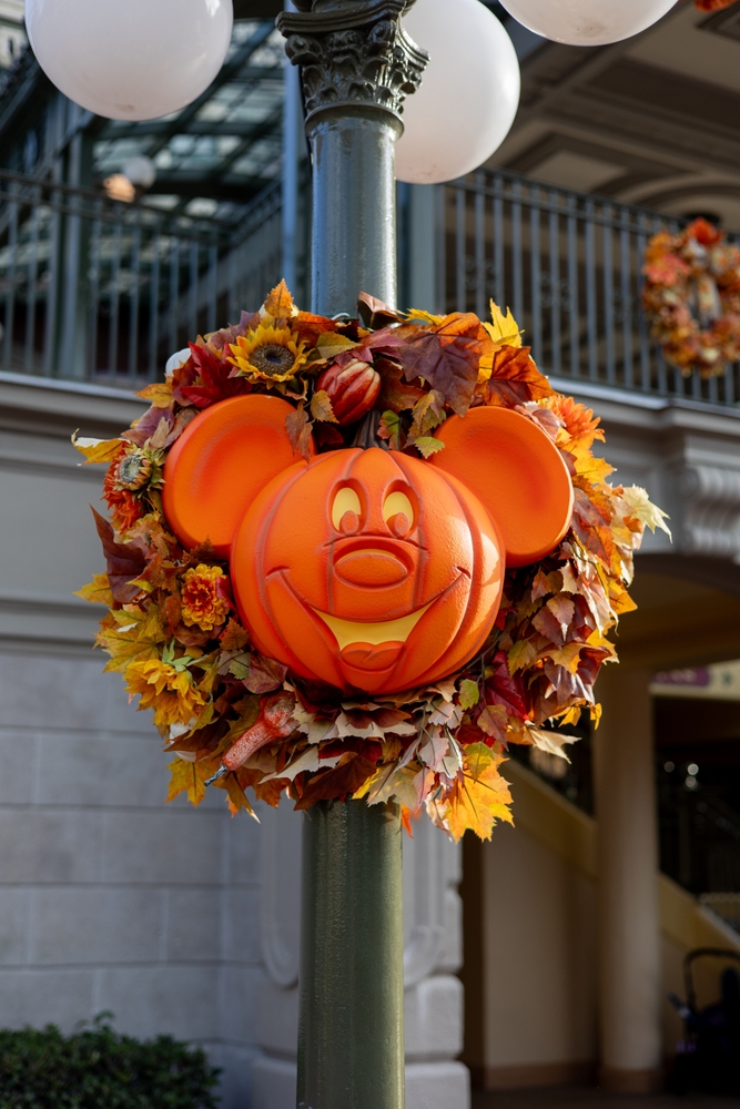 A smiling pumpkin Mickey Mouse laid in an autumn wreath greets guests on their way to Cinderella's Castle at Mickey's Not-So-Scary Halloween Party, the ultimate way to celebrate Halloween in Florida.