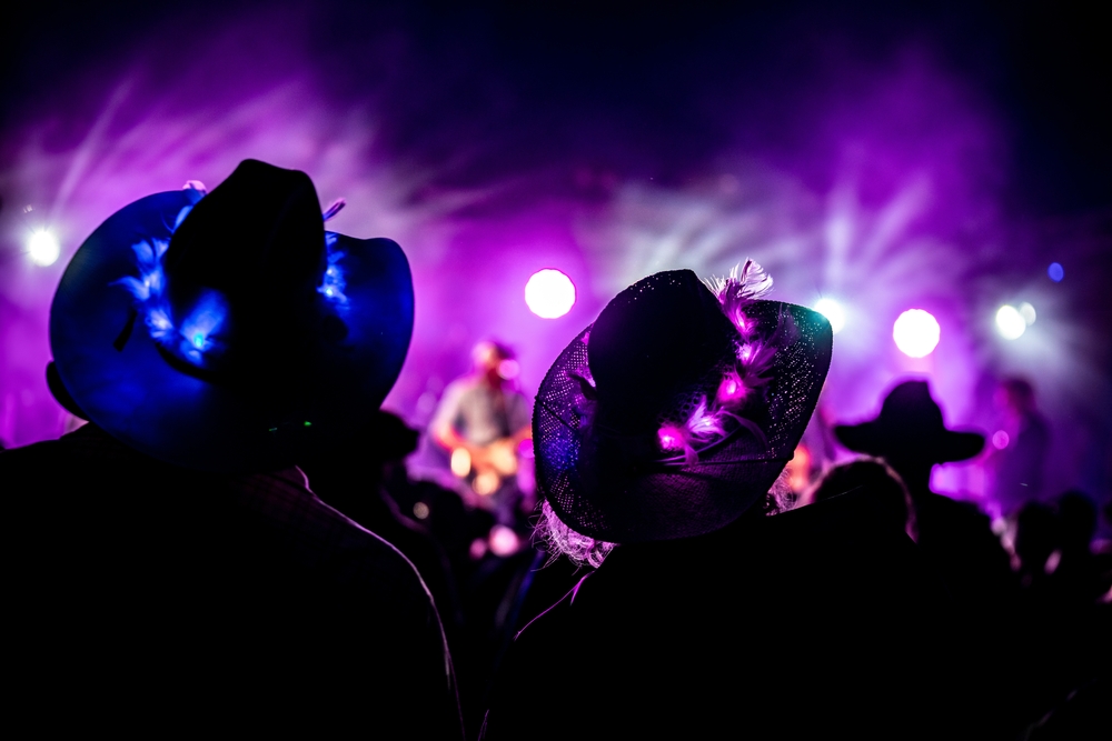 two people wearing light up cowboy hats in the dark at a music festival in florida