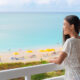 woman standing on the balcony of a florida beach resort and looking out over the ocean