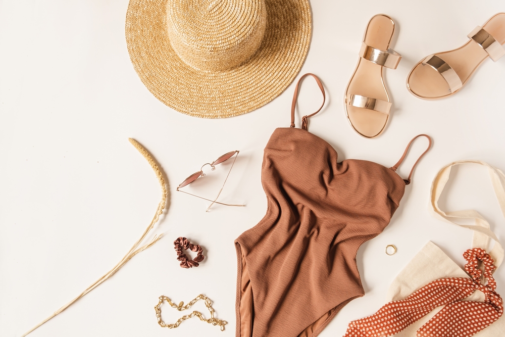 a picture of a swimsuit hat, sandals and sunglasses with bag