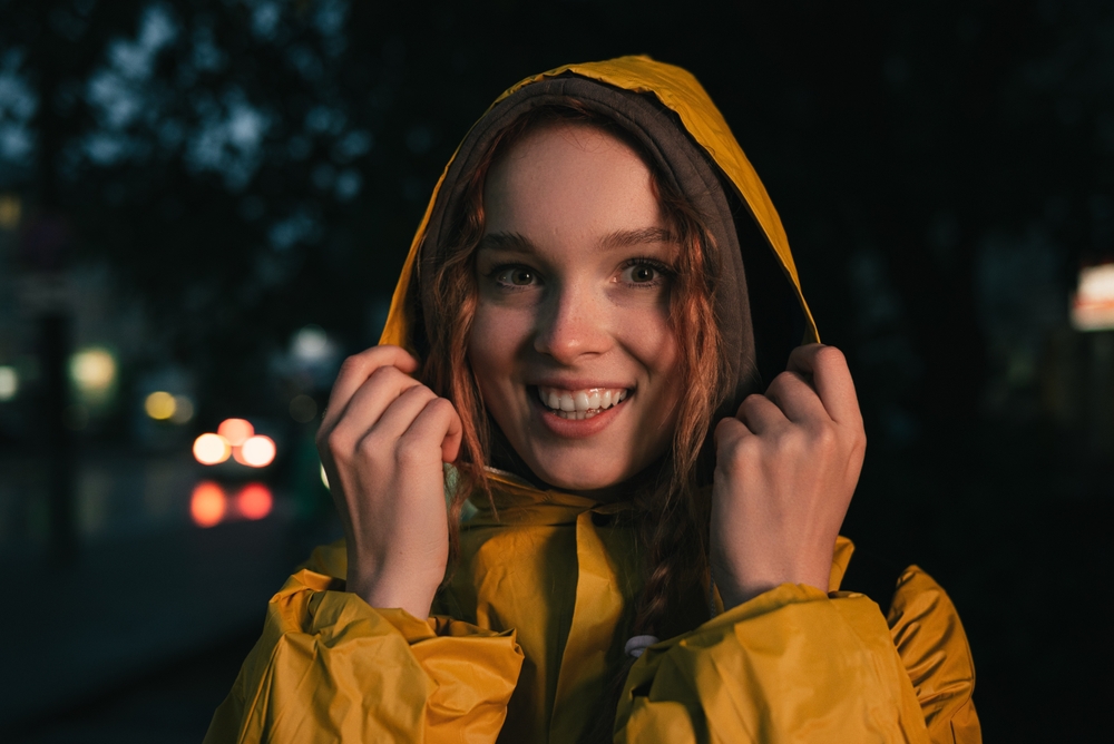 A women poses in a yellow rain jacket, prepped for the weather in Miami! 