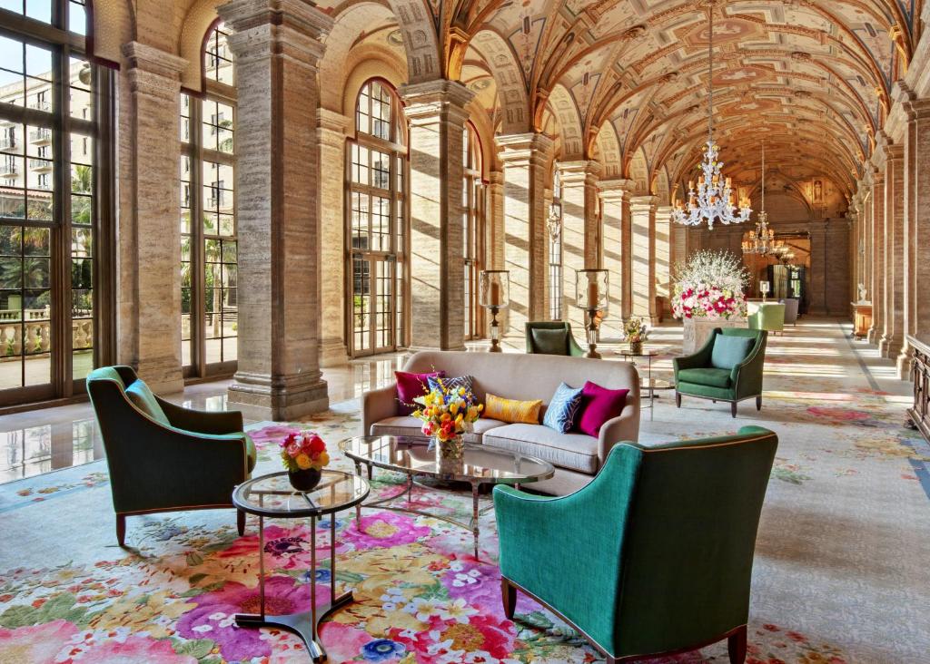 Wonderful lobby area with arches and large glass windows. There are colorful chairs and tables. 