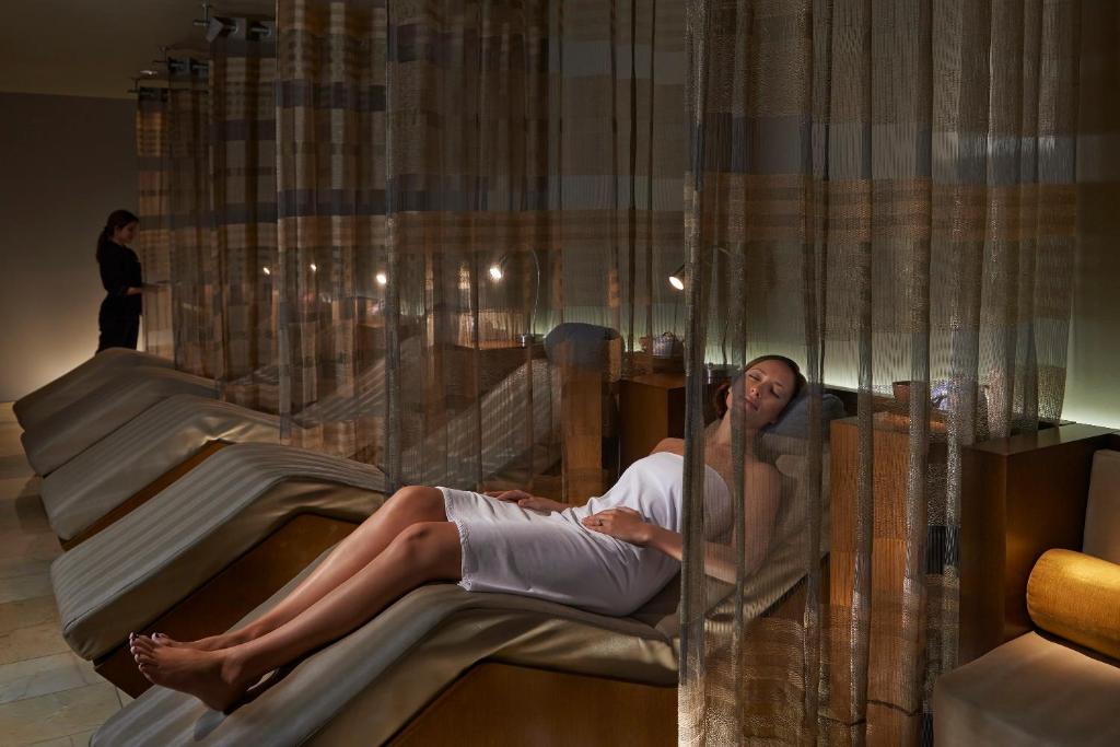 A woman laid down on a bed in a spa. The article is about the best spa resorts in Florida. 