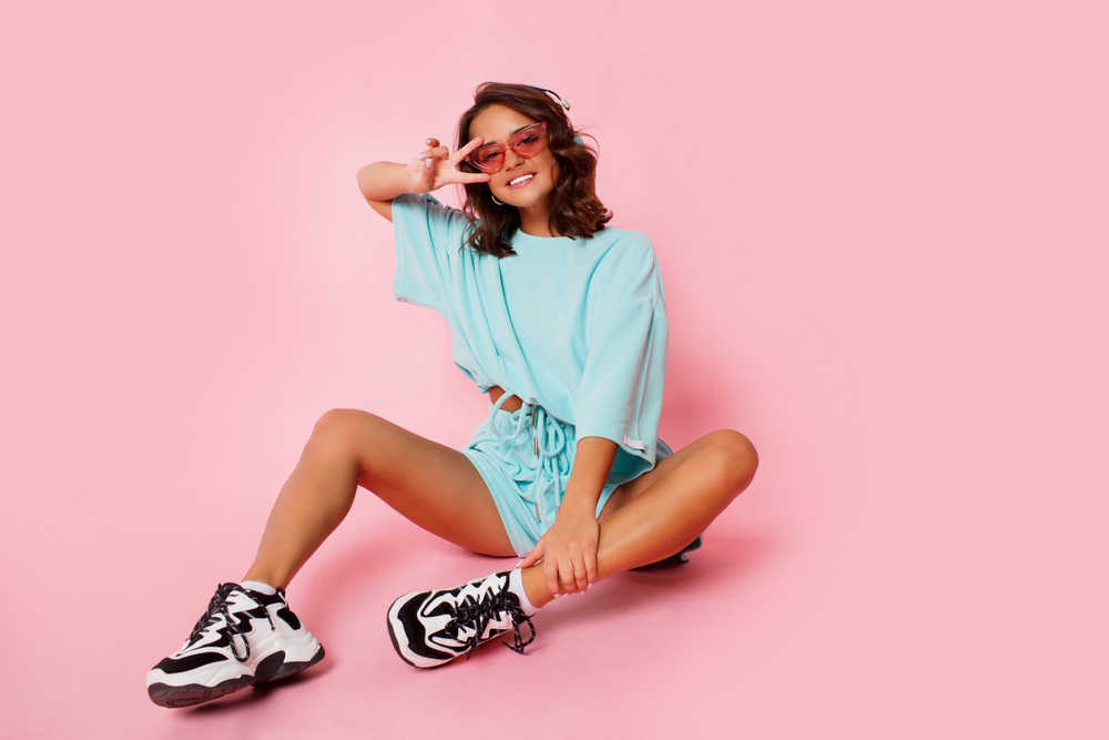 A girl poses with her black and white trainers, and her matching athletic set: she throws a peace sign, comfortable with what she chose to wear in Orlando. 