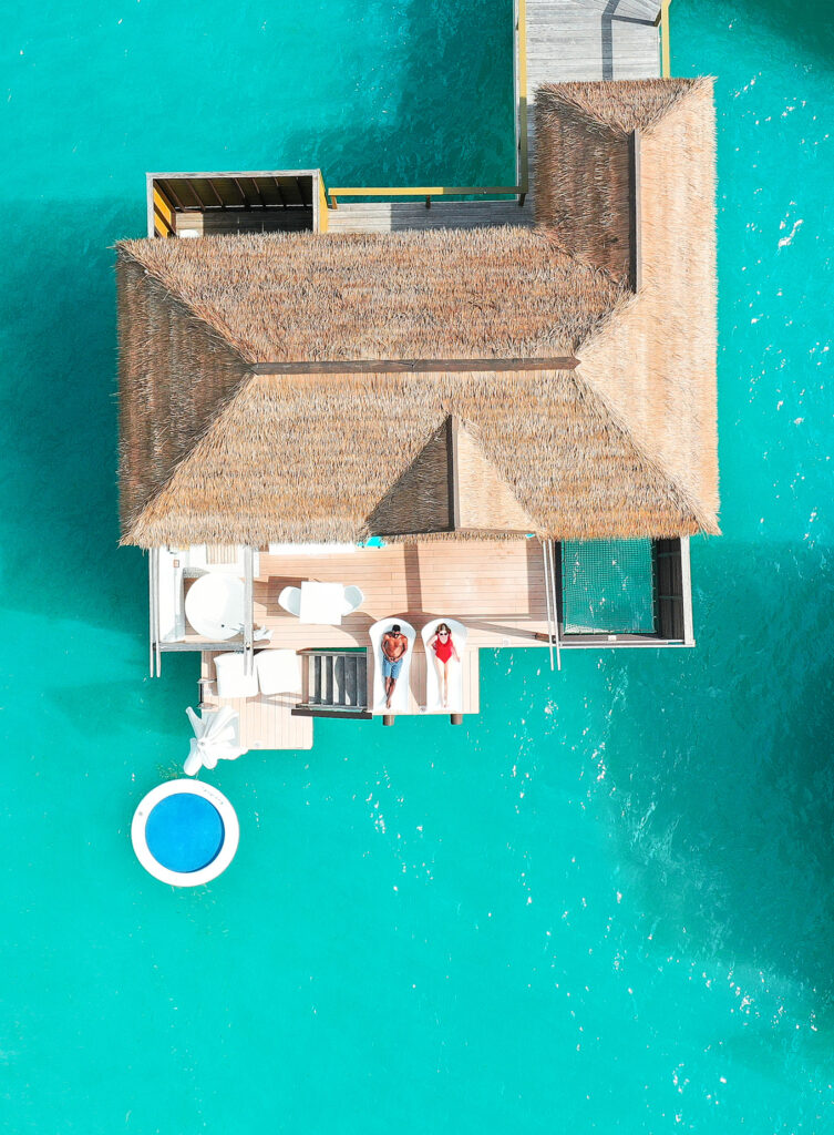 Two people laying on deck of one of the overwater bungalows near Florida 