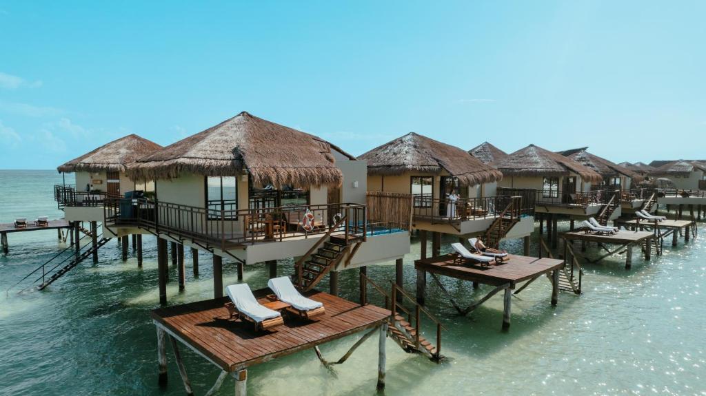 thached overwater bungalows near Floridawith stairs down to a deck with loungers. 