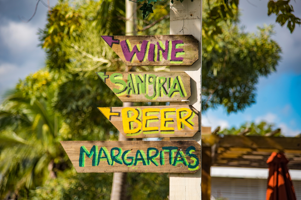 A wooden sign points guests in the correct location to go get wine, sangria, beer and margaritas.