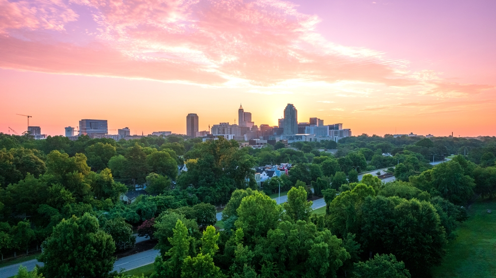 When considering the cheapest places to fly from Fort Lauderdale, look at Raleigh: this photo shows the greenery around the city at sunset, and how the urban meets nature well.
