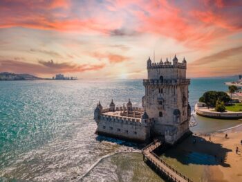 Aerial view of Tower of Belem at sunset, Lisbon, Portugal on the Tagus River. it is sunset and the water is blue