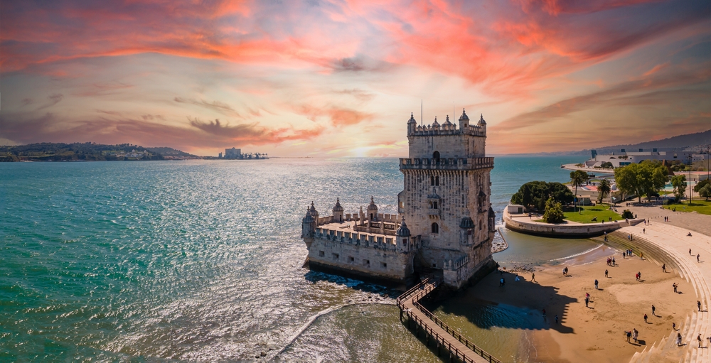 Aerial view of Tower of Belem at sunset, Lisbon, Portugal on the Tagus River. This article is about cheapest places to fly from Miami.