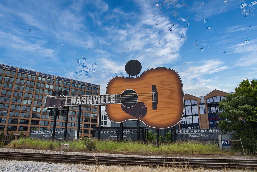In Nashville, a giant shaped guitar stands as a mural in front of apartment buildings, representing the iconic music scene, since this city is one of the cheapest places to fly from Orlando.