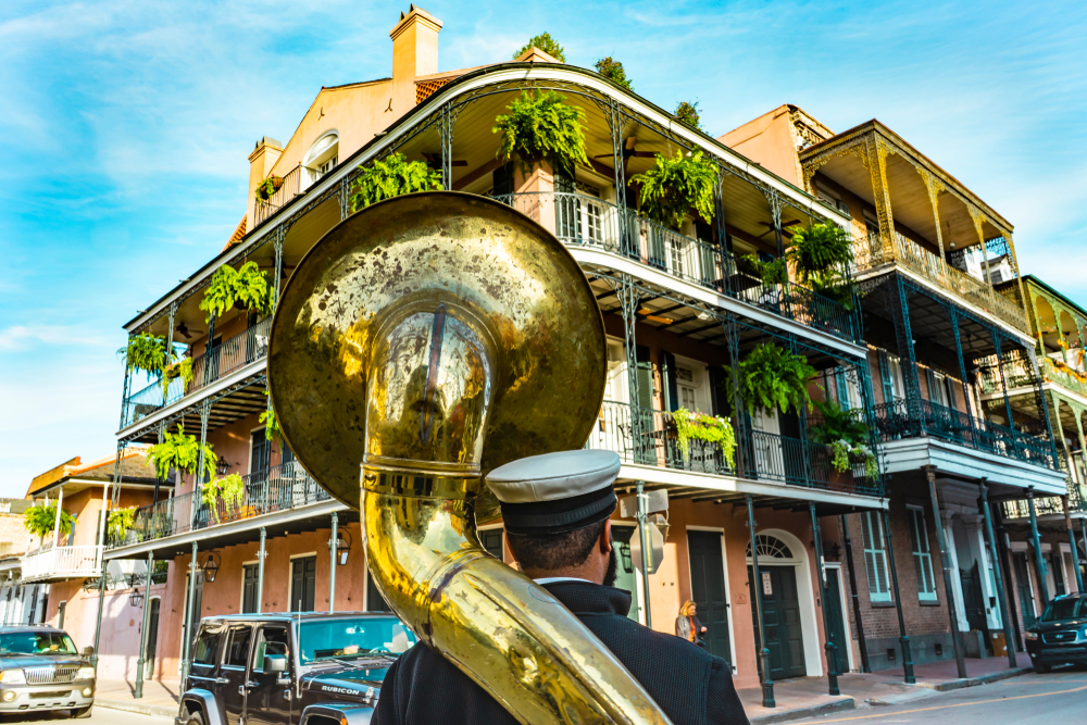 One of the cheapest places to fly from Tampa is NOLA: a man with a tuba stands on the corner of the French Corner, playing in this photo. 