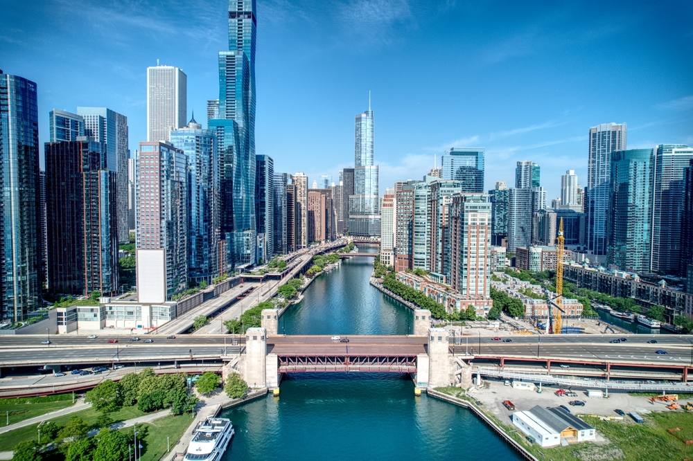 A drone shot shows the iconic skyline of Chicago with all its tall buildings, windows, brides, river and more.