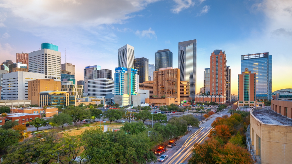 One of the cheapest places to fly from Tampa is Huston, with its ever growing city: this cityscape shows tall buildings at sunset, cars rolling by and more. 